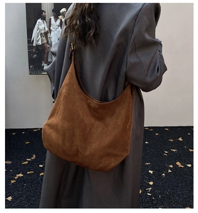 Close-up of brown suede hobo bag with matte finish and metallic ring hardware detail