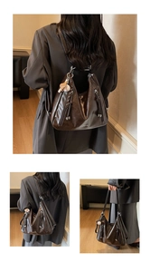 Detail of dark brown vintage leather tote with baseball charm and tassel zipper