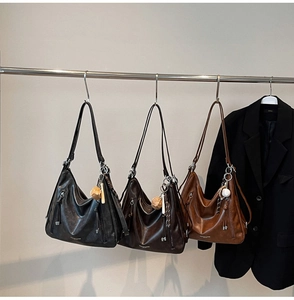 Close-up of three vintage oil wax leather hobo bags in black, coffee, and caramel colors