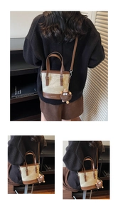 Détail d'un sac seau beige texturé avec finitions en cuir marron et un charm monstre