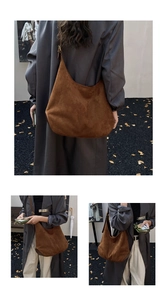 Macro view of brown faux suede tote bag with reinforced base and adjustable strap detail