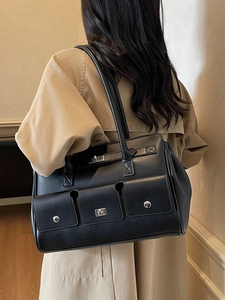 Minimalist black multi-pocket shoulder bag in textured faux leather with silver buckles