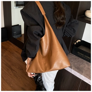 Detail of soft brown PU leather tote bag showing large capacity and smooth texture