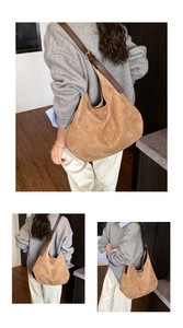 Detail of tan faux suede hobo bag featuring dark leather strap and gold metal buckle