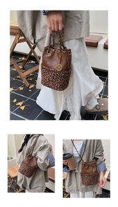 Close-up of quilted leather and leopard print fabric on a stylish bucket bag with chain strap