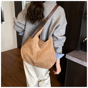 Detail of camel suede hobo bag with adjustable brown leather strap and bronze buckle