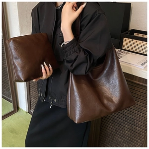 Detail of dark brown tote set with retro oil wax texture and matching inner pouch