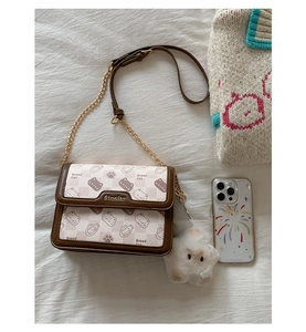 Detailed close-up of a Bread Cat printed flap bag with a plush star charm and gold chain