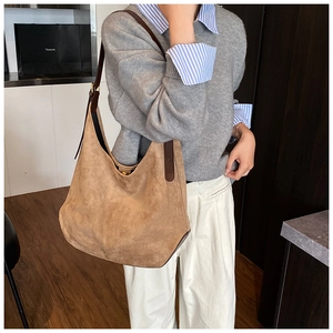 Brown suede tote bag with leather straps shown as a side view on a model for daily commute