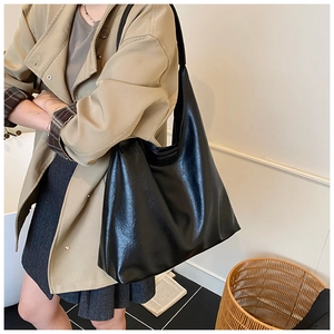 Detail view of large black hobo tote bag with retro pleated texture for daily commute