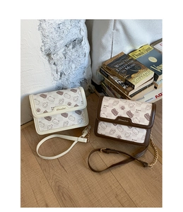 Detail view of cartoon bread cat pattern on checkerboard crossbody shoulder bag