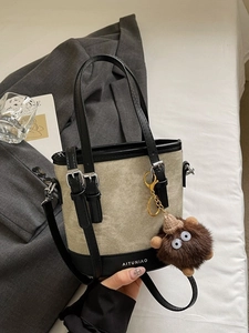 Sac seau chic en toile et cuir avec poignées et un pendentif en peluche ludique