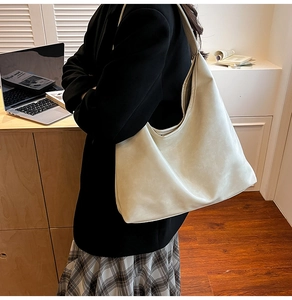 Gros plan d'un sac hobo en cuir souple crème montrant la texture et la capacité