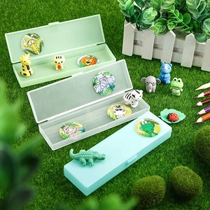 Detail view of animal stationery set with pencil cases and erasers on grass