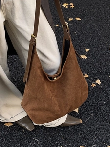 Brown large suede hobo bag with adjustable strap shown in an autumn street setting