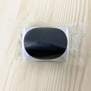 Detail view of round black PVC chalkboard labels in a roll with protective film
