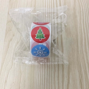 Close-up of a roll of Christmas theme stickers with tree and snowflake designs