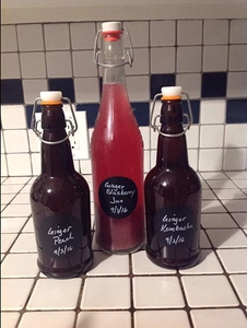 Detail of round black chalkboard labels applied on vintage glass swing top storage bottles