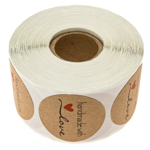 Roll of kraft paper stickers with handmade with love text and red heart on white background