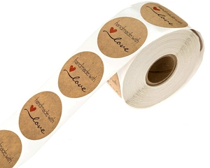 Macro detail of round kraft paper stickers featuring handmade with love text and red heart