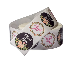 Detail of round Thank You stickers in rolls featuring floral patterns and elegant script