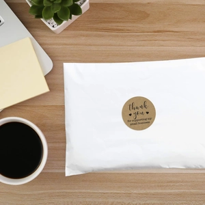 Close-up of Thank You Kraft paper stickers on white shipping envelope for small businesses