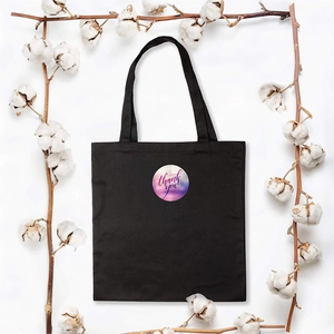 Detail of black canvas tote bag with silk-screened thank you logo and cotton decor