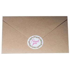 Brown kraft paper envelope with decorative floral Thank You sticker seal on white background