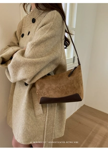 Brown suede baguette shoulder bag shown on model for a minimalist vintage look