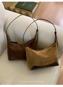Close-up of vintage suede underarm bags with leather stitching on a white sofa