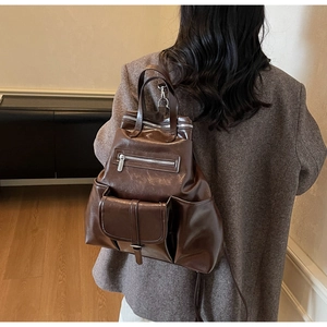 Détails d'un sac cabas vintage marron foncé avec plusieurs poches et une finition brillante