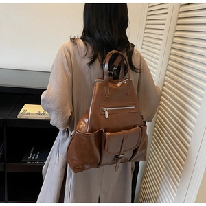 Vue détaillée du sac à dos en cuir marron avec plusieurs poches zippées sur un mannequin