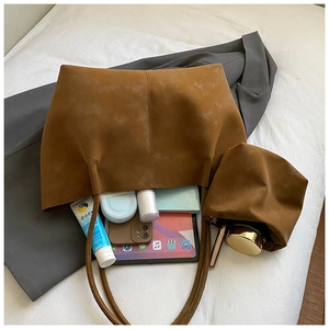 Vue détaillée de l'intérieur du grand sac en daim caramel et sa pochette assortie