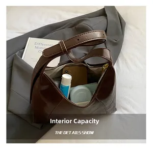 Detail view of brown faux leather bag interior showing space for phone and cosmetics