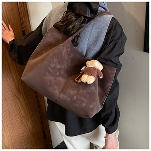 Sac cabas en similicuir suédé marron avec pendentif ours présenté en porté épaule élégant