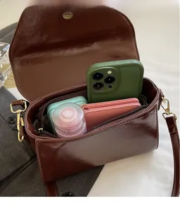 Detail view of the deep brown leather crossbody bag showing its spacious internal capacity
