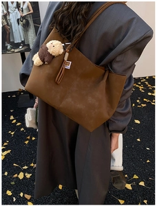 Détail du grand sac cabas en daim marron avec franges et porte-clés ours en peluche