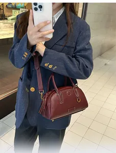 Dettaglio della borsa Boston in pelle martellata bordeaux con finiture dorate