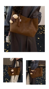 Détail d'un sac cabas en daim marron avec pendentif ours et breloque à pompons frangés