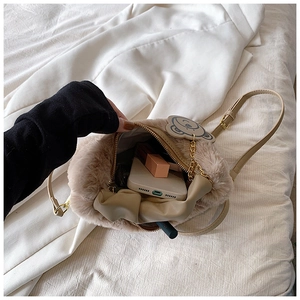 Vue de dessus de l'intérieur du sac peluche beige avec fermeture éclair et pendentif ours