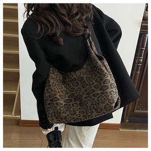 Close-up of leopard print hobo tote bag texture and soft fabric on person's shoulder