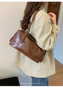 Detail of vintage brown oil wax leather crossbody bag showing stitching and silver hardware