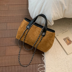 Close-up of vintage brown faux suede tote bag with black leather trim and metal chain strap