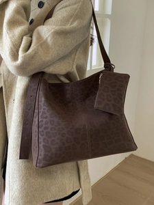 Sac fourre-tout léopard avec mini pochette porté sur manteau beige style automne hiver