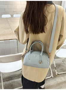 Vista dettagliata di una borsa Boston azzurra indossata come borsa a tracolla