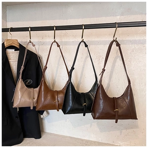 Detail of four vintage-style shoulder bags hanging with fine straps and gold buckles