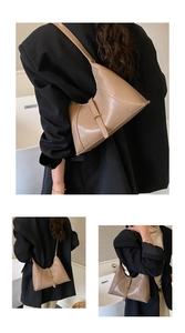 Detail view of khaki crescent shoulder bag with metallic buckle on smooth leather