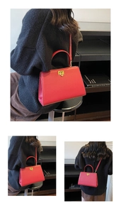Détail du sac à main trapèze rouge avec fermoir doré et texture cuir élégante