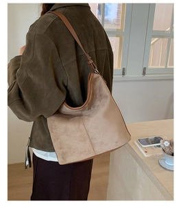 Brown suede tote bag shown in use, highlighting its large capacity and soft texture