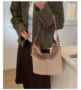 Detail of vintage suede hobo bag in khaki with brown leather strap worn by a model